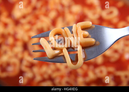 "U" geschrieben in Spaghetti Nudeln Liebesbriefe & ruht auf einer Gabel für eine besondere Botschaft für den Valentinstag. Stockfoto