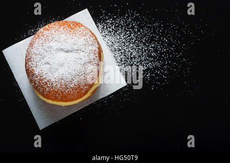 Donut und Puderzucker auf dunklem Hintergrund Stockfoto