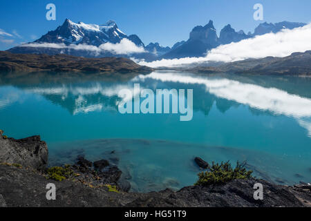 Clearing-Nebel über Lago Pehoe. Ein paar niedrige Wolken bleiben, verdeckt die Grundlagen der Paine Grande und die Cuernos del Paine.  Die stillen Wasser des Sees pr Stockfoto