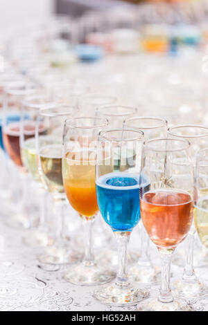 Viele Gläser von verschiedenen Alkohol hintereinander am Tresen Stockfoto