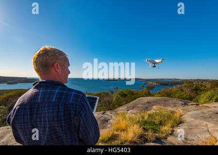 Ein Mann fliegt eine Drohne in einem Park in Sydney, Australien Stockfoto