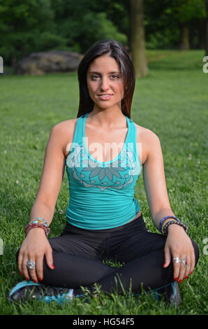 Attraktive junge Mischlinge Frau praktizieren Yoga im Central Park in New York City Stockfoto