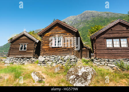 Blick über See Lovatnet, sitzt ein traditionelles norwegisches Haus im Vordergrund mit Sod Dach gekrönt. Stockfoto