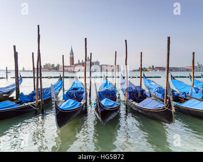 Gondeln, die auf dem Canale Grande in der Nähe des Markusplatzes in Venedig festgemacht sind, blicken auf die Kirche San Giorgio Maggiore. Stockfoto