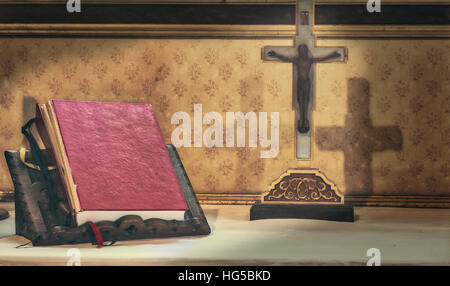 Kreuz und Bibel auf einem Altar im Inneren Stockfoto