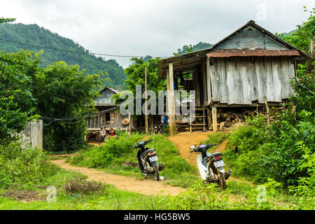 Bauernhof Hütte in einem abgelegenen vietnamesischen Dorf.  Reisfelder in den Vordergrund, Berge im Hintergrund. Stockfoto