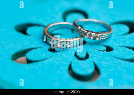 zwei Trauringe Weissgold auf Türkis Hintergrund Stockfoto