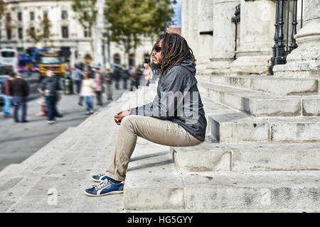 schwarzer Mann.  Mann zu betrachten.   Dreadlocks.  Rastafari.   Allein in der Stadt. Stockfoto