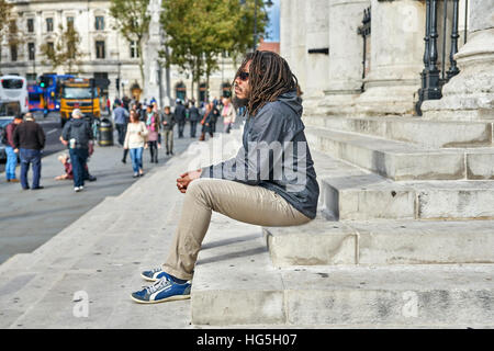 schwarzer Mann.  Mann zu betrachten.   Dreadlocks.  Rastafari.   Allein in der Stadt. Stockfoto