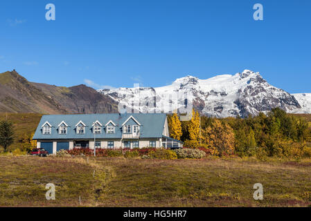 Landschaft mit einem isländischen Heimat und schneebedeckten Bergen im Hintergrund. Stockfoto