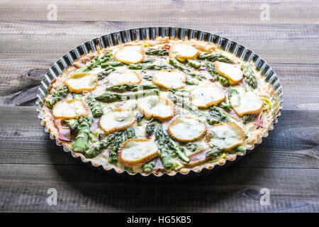 Tarte mit Spargel, Mozzarella und Schinken auf Holztisch Stockfoto