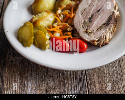 Hackbraten mit Bratkartoffeln, eingelegte Pilze, Cherry-Tomaten und Gurken. Selektiven Fokus Stockfoto