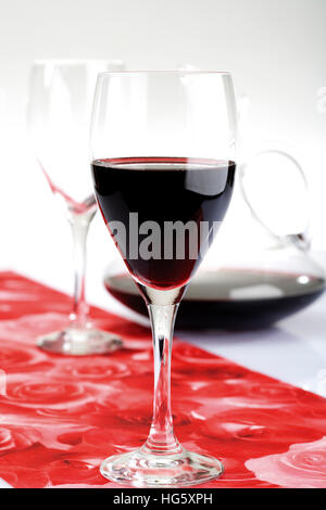 Rotweingläser auf Tischläufer mit Wein Dekanter im Hintergrund Stockfoto