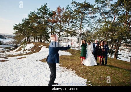 Trauzeuge mit Brautjungfern und Brautpaar trinken Champagner auf Frost-Winter-Hochzeit. Stockfoto