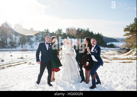 Trauzeuge mit Brautjungfern und Brautpaar trinken Champagner auf Frost-Winter-Hochzeit. Stockfoto