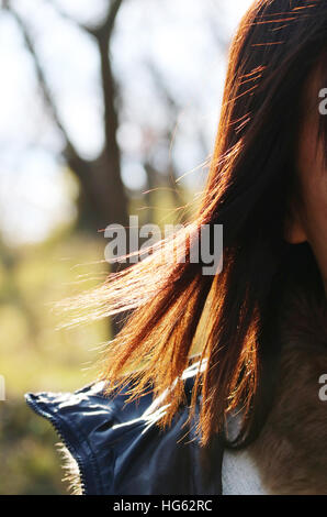 Junge Frau mit Haaren im Freien bei Sonnenlicht Stockfoto