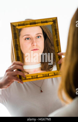 Doppelgänger / Alter Ego unter dem Motto Fotoshooting: eine junge Frau-Mädchen ihre Reflexion in einem Spiegel betrachten statt mein ein "Zwilling" tragen die gleiche Kleidung Stockfoto