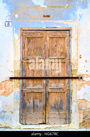 alte Holztür mit Eisenstange gesperrt Stockfoto