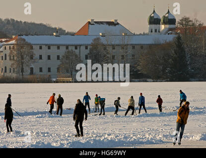 Seeon, Deutschland. 3. Januar 2017. Eishockey-Spieler und Eisläufer Spaß vor dem Hintergrund der Seeon Abbey in Seeon, Deutschland. 3. Januar 2017. Am 4. Januar 2017 beginnt die CSU (christlich-soziale Union) regionale Fraktion ihre Winter mit starken Sicherheitsvorkehrungen in der Abtei. Foto: Diether Endlicher/Dpa/Alamy Live News Stockfoto