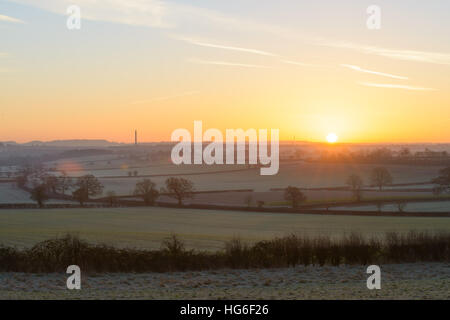 Lange Itchington, in der Nähe von Leamington Spa, Warwickshire, UK. 5. Januar 2017. Einem kalten frostigen Start in den Tag mit einer Temperatur von - 5.5ºC in ländlichen Warwickshire. Die Cemex Schornstein gegen einen farbenfrohen Sonnenaufgang. © Dan Tucker/Alamy Live-Nachrichten Stockfoto