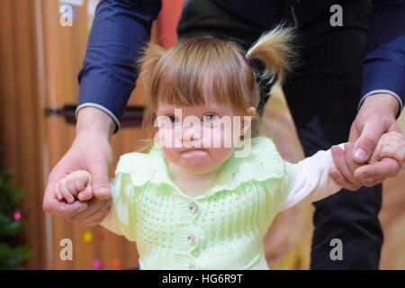 Einjähriges Baby Mädchen in Engelsflügel. Kind mit dem Papst. Vater hält Tochter in der hand. Ein Kind spielt. Blonde Mädchen. Stockfoto