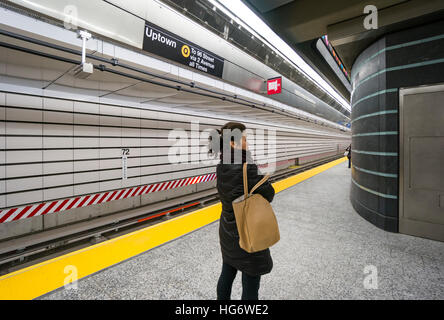 Eine asiatische Frau wartet ein Uptown Zug an der 72nd Straße Station der Second Avenue U-Bahn in New York City Stockfoto