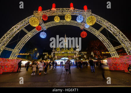 Menschen besuchen den Weihnachtsmarkt in der Nähe von Rathaus am Abend Stockfoto