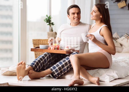 Gut aussehend lächelnder Mann hält ein Tablett mit Essen Stockfoto