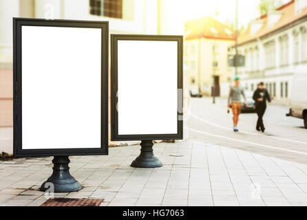 Zwei leere Werbetafeln auf der Stadtstraße mit Fußgängern und Sonne glühen Stockfoto