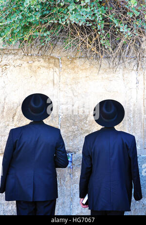 Zwei jüdische Männer tragen schwarze Anzüge und Hüte, beten an der westlichen Wand in Jerusalem Stockfoto