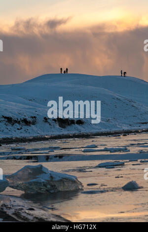 Touristen fotografieren auf dem Berg Am Gletschersee Jökulsárlón Gletscherlagune, an den Rand des Vatnajökull National Park, bei Tagesanbruch, Island im Januar Stockfoto