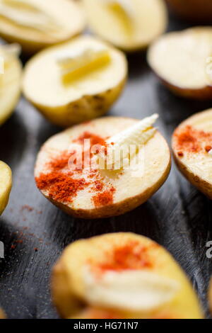 Kartoffeln mit Butter und Pfeffer rot auf schwarzem Teller Stockfoto