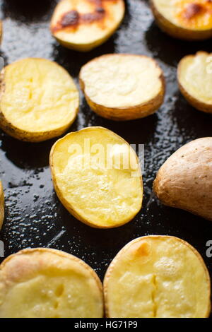 Gebackene Kartoffel auf einem schwarzen Backblech Stockfoto