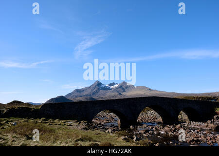 Kleine Steinbrücke mit drei Bögen über einen niedrigen Fluss, Berge im Hintergrund in der Nähe von Sligachan Skye. Stockfoto