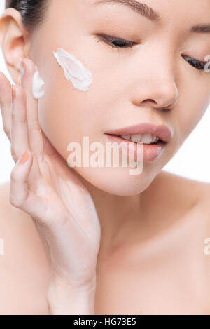 Schöne positive Frau Auftragen der Creme im Gesicht Stockfoto