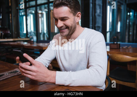 Blick auf den Bildschirm seines Smartphones schön glücklich Stockfoto