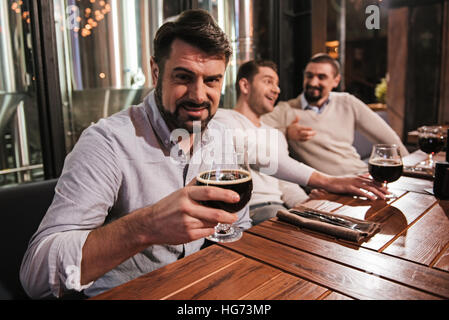 Hübscher bärtigen Mann hält ein Glas mit Bier Stockfoto