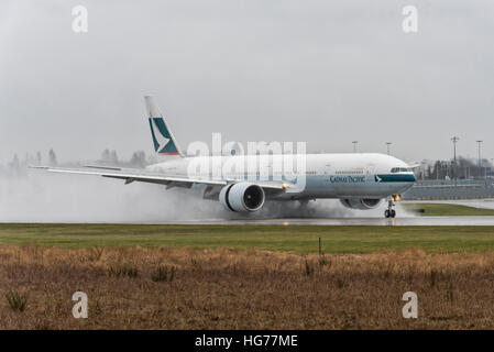 Cathay Pacific Boeing 777-300 auf einem nassen Piste am Vancouver International Airport landen. Stockfoto