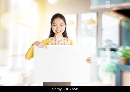 Junge asiatische Frau Hand hält ein leeres weißes Papier Karte steht in ihr Café. Platz für Text zu kopieren. Stockfoto