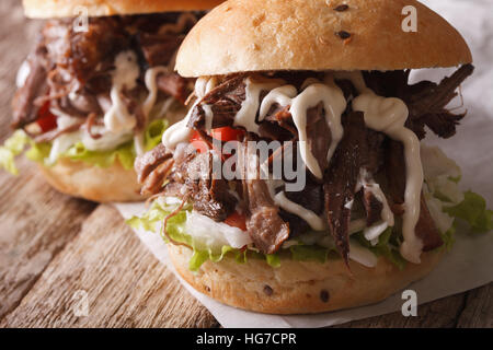 köstliche gezogener Schweinefleisch Sandwich mit Krautsalat und Sauce Nahaufnahme auf dem Tisch. Horizontale Stockfoto