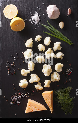 Kochen: Blumenkohl mit Zutaten auf einem Steintisch. vertikale Ansicht von oben Stockfoto