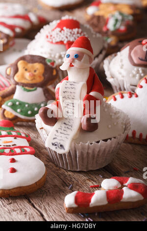 Weihnachten-Cupcakes und Lebkuchen Cookies Makro auf einem Holztisch. Vertikal Stockfoto