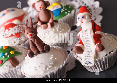 Weihnachts-Muffins: Weihnachtsmann und Rentier Makro auf dem Tisch. horizontale Stockfoto