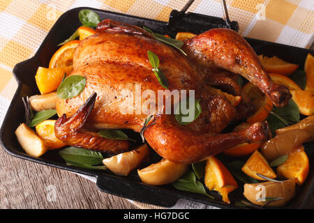 Weihnachtsbraten Huhn mit Orangen und Äpfel Nahaufnahme in einer Pfanne. horizontale Stockfoto
