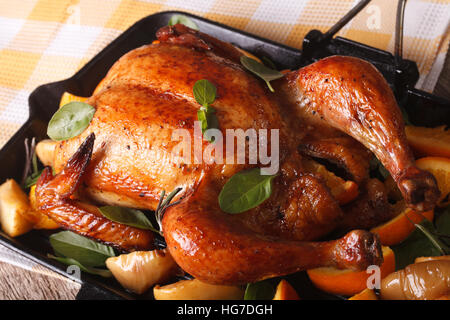 ganzes Huhn mit Orangen und Äpfel Nahaufnahme in einer Pfanne gebraten. horizontale Stockfoto