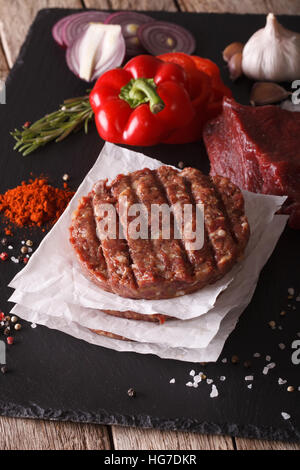 Rohen Boden Rindfleisch Fleisch Burger Steak Schnitzel mit Zutaten auf dem Brett. vertikale closeup Stockfoto