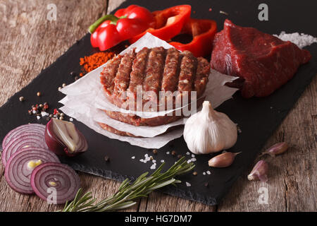 Rohe Burger Schnitzel Nahaufnahme mit den Zutaten auf den Tisch. horizontale Stockfoto