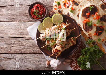 Chicken Tikka auf Spieße, Naan Fladenbrot und Chutney. horizontale Ansicht von oben Stockfoto