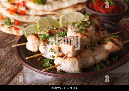 Indisches Tikka Hähnchenspieße auf Spieße Nahaufnahme auf einen Teller und Naan. Horizontale Stockfoto