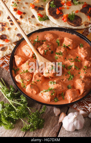 Chicken Tikka Masala und Naan Fladenbrot close-up auf dem Tisch. vertikale Stockfoto